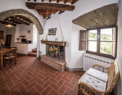 - un salon avec une cheminée, une table et des chaises dans l'établissement Casa Selvolini - VOLPAIA, à Radda in Chianti