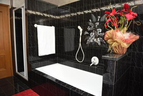 a black tiled bathroom with a sink and a shower at Casa Dante in Romano di Lombardia