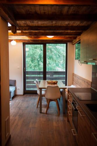 a kitchen and dining room with a table and chairs at Apartmán Ježko in Tale