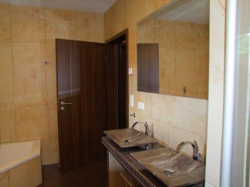 ein Badezimmer mit zwei Waschbecken und einem Spiegel in der Unterkunft Ferienhaus "Kräuterhexe" mit Wasserbett 200x200cm in Wernigerode