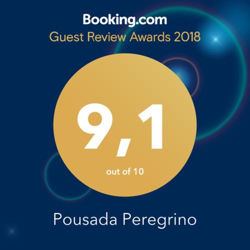a sign that reads quest review awards with a yellow circle at Pousada Peregrino in Barra de Jacuípe