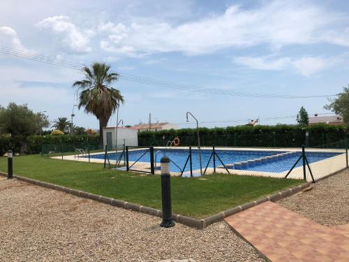 a swimming pool with a swing set in a park at Pis la rapita in Alcanar