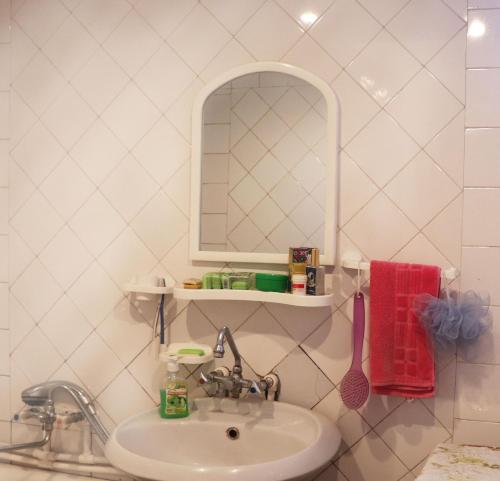 ein Bad mit einem Waschbecken und einem Spiegel in der Unterkunft Nina BNB in Sewan