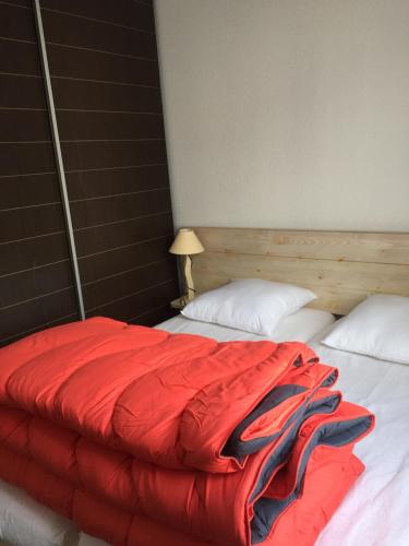 - un lit avec une couverture rouge dans l'établissement Loc luz st sauveur 3, à Luz-Saint-Sauveur