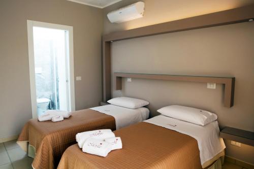 2 Betten in einem Hotelzimmer mit Handtüchern darauf in der Unterkunft Morfeo in Pozzallo