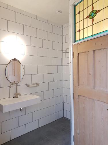 a bathroom with a sink and a mirror at SintAnna B&B PetitHotel in Yerseke