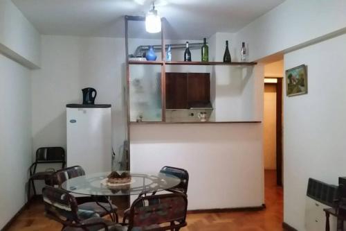 una sala da pranzo con tavolo in vetro e sedie di Edificio Independencia Lavalle 35 a Mendoza