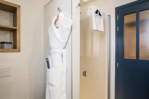 a white robe hanging on a wall next to a door at MADISON Saint Jean de Luz - Handwritten Collection in Saint-Jean-de-Luz