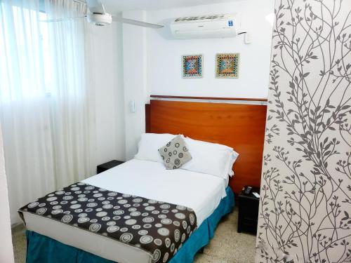 um quarto com uma cama com um cobertor preto e branco em Hotel Radoa em El Banco