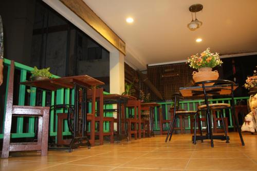 a bar with chairs and tables and a vase of flowers at Tamarind Residences Khonkaen บ้านแทมมารีน in Khon Kaen