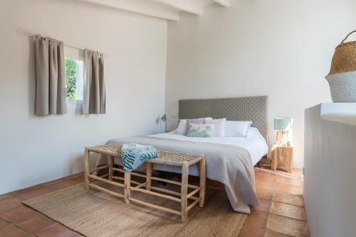 a white bedroom with a bed and a table at Ca Sa Padrina in Sóller