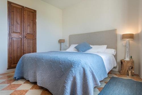 a bedroom with a bed with a blue blanket on it at Ca Sa Padrina in Sóller