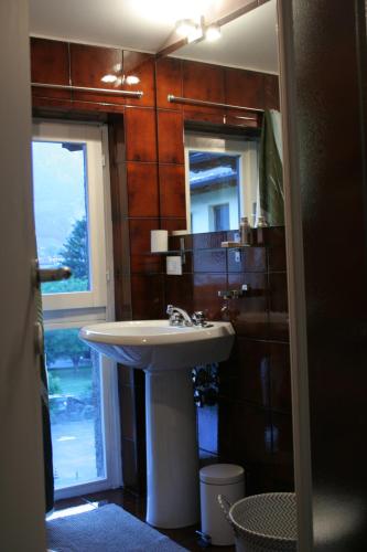 La salle de bains est pourvue d'un lavabo et d'un miroir. dans l'établissement Residence Gemma, à Riva del Garda