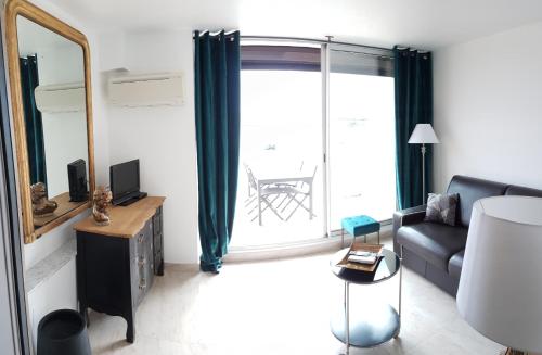 a living room with a couch and a mirror at Heliopolis in Cap d'Agde