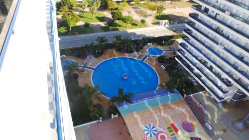 Playa de GandiaにあるApartamento El Eden Playa de Gandíaのホテルの隣にあるスイミングプールのオーバーヘッドビュー