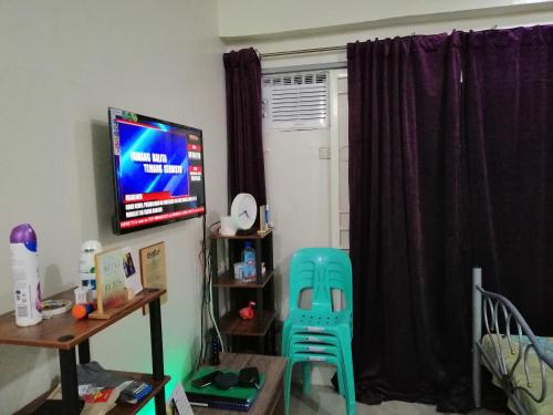 a room with a television and a chair and a table at Condo Transient Near NAIA Airport-Unlimited Internet v2 in Manila