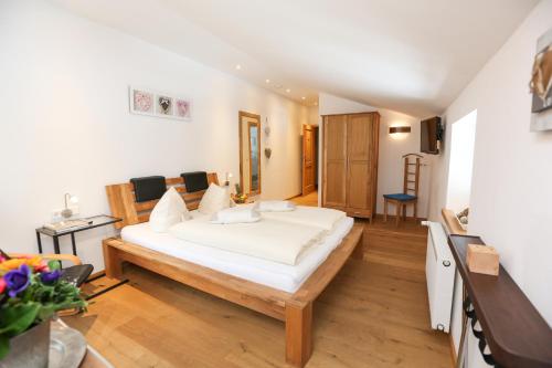 a bedroom with a large white bed in a room at Schwaigeralm in Kreuth
