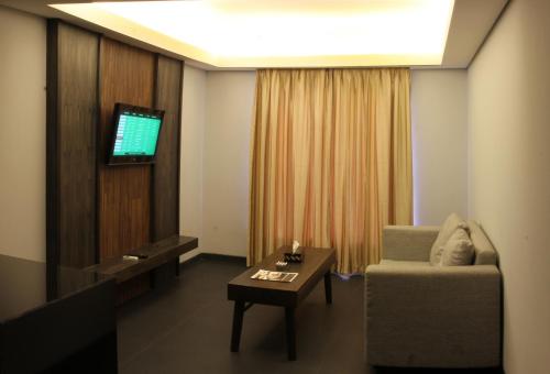 a living room with a couch and a tv at Ping Hotel Seminyak Bali in Seminyak