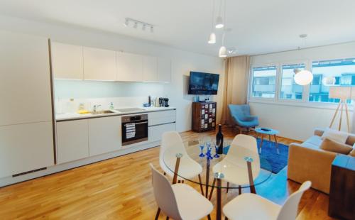 a kitchen and living room with a table and chairs at BestVienna U1 Kagran/DZ in Vienna
