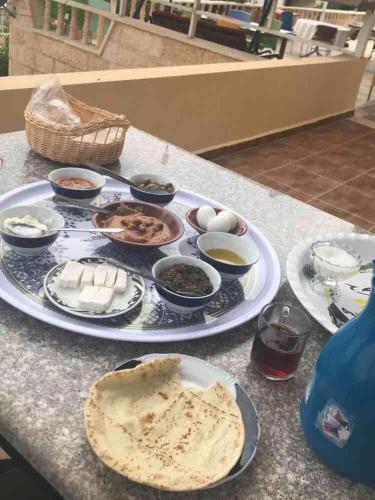 a table topped with plates of food on a table at Murshed Motel in Ash Shūnah ash Shamālīyah