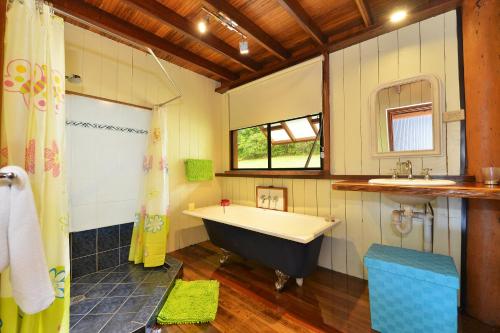 a bathroom with a tub and a sink at Tea Tree Cottage in Diwan