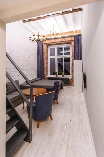 Un comedor con mesa y sillas y una ventana. en MoHo L, en Wroclaw