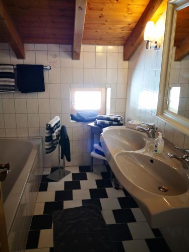 a bathroom with a sink and a tub and a toilet at Jungholz Erlebnis in Jungholz
