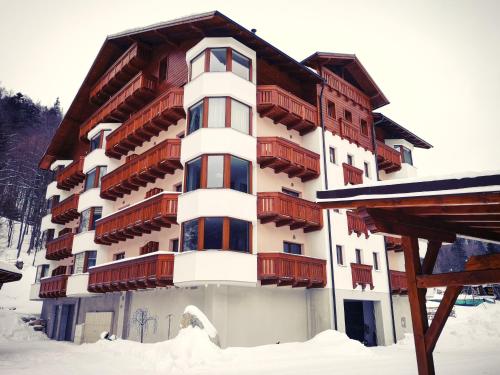 a large building with snow in front of it at Romantic Chopok Juh Apartment 22 in Tale