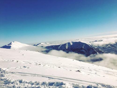 a snow covered mountain with clouds in the background at Romantic Chopok Juh Apartment 22 in Tale