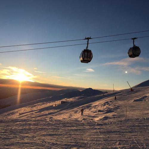 a ski lift with people skiing down a snow covered slope at Romantic Chopok Juh Apartment 22 in Tale