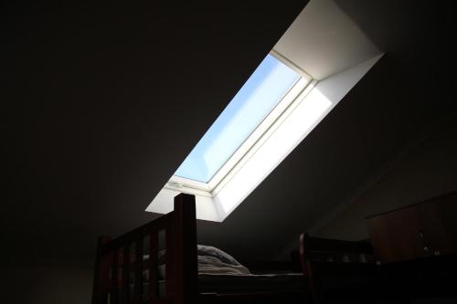a skylight in a bedroom with a bed and a window at Lions Heart Hostel in Lviv