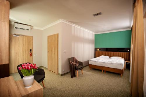 um quarto de hotel com uma cama, uma mesa e cadeiras em Akacja Medical Resort em Ciechocinek
