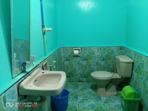 Valine Grace Cottages في إل نيدو: حمام مع حوض ومرحاض