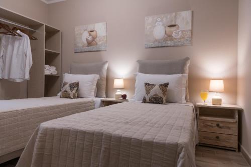 a bedroom with two beds with pillows and two lamps at V. P. Place. in Argostoli