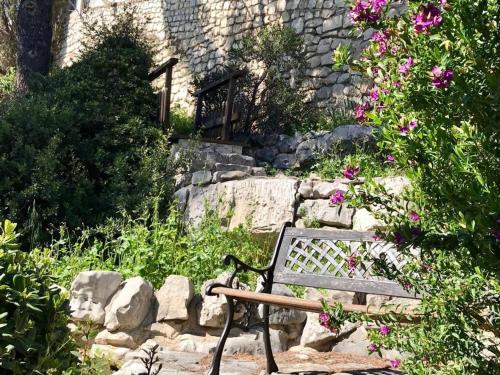 un banc en bois installé dans un jardin fleuri dans l'établissement Beautiful Villa 5 min from Monaco, à Cap d'Ail