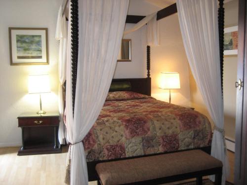 una camera con letto a baldacchino e 2 lampade di Motel Iberville a Saint-Jean-sur-Richelieu