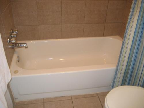 a white bath tub in a bathroom with a toilet at Motel Iberville in Saint-Jean-sur-Richelieu