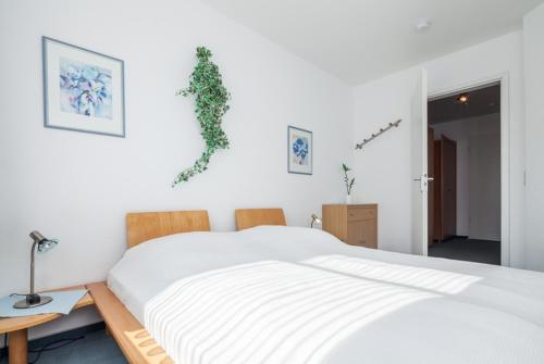 una camera da letto con un grande letto bianco con lenzuola bianche di 17 Dünenweg Dünenblick a Boltenhagen