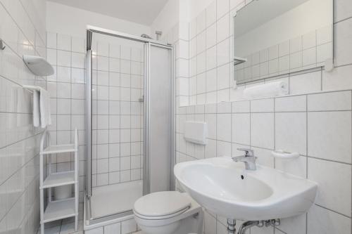 ein weißes Bad mit einem WC und einem Waschbecken in der Unterkunft 17 Dünenweg Dünenblick in Boltenhagen