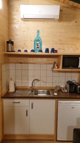 a kitchen with a sink and a bottle on a shelf at Las casas de Colinas in Vejer de la Frontera