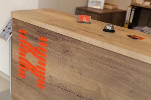 a wooden counter with orange writing on it at Hugo Hotel in Varna City