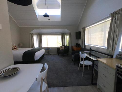 ein Hotelzimmer mit einem Bett, einem Schreibtisch und einer Küche in der Unterkunft The Ohakune Central Motels in Ohakune