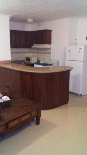 a kitchen with a wooden counter and a white refrigerator at Rolando share apart in Punta Cana