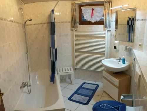 a bathroom with a tub shower and a sink at Ferienwohnung mit Terrasse in Grimma
