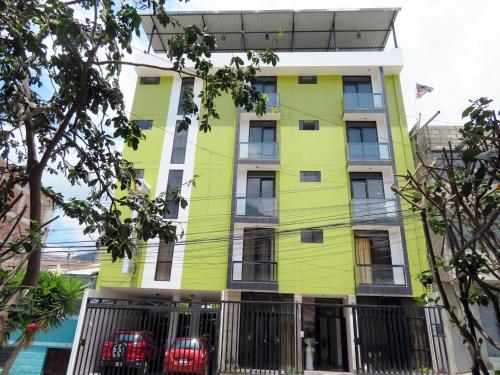 a yellow building with two cars parked in front of it at Reggio Green Hotel in Abancay