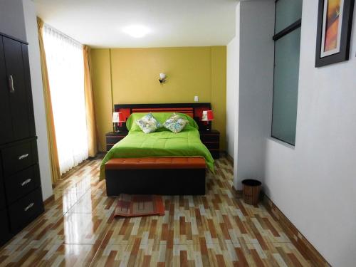 a bedroom with a green bed and a window at Reggio Green Hotel in Abancay