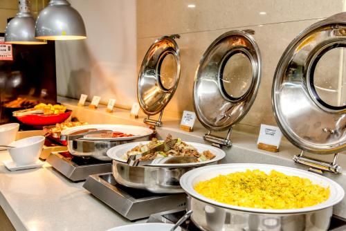 a buffet with several dishes of food on a counter at Ramada by Wyndham Jeju City Hall in Jeju