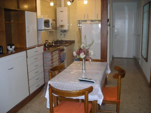 eine Küche mit einem Tisch und einer Blumenvase darauf in der Unterkunft Bolivar y Guemes Frente Al Mar in Mar del Plata