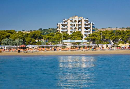 ein Hotel am Strand mit Liegestühlen und Sonnenschirmen in der Unterkunft Hotel Parco Dei Principi in Giulianova