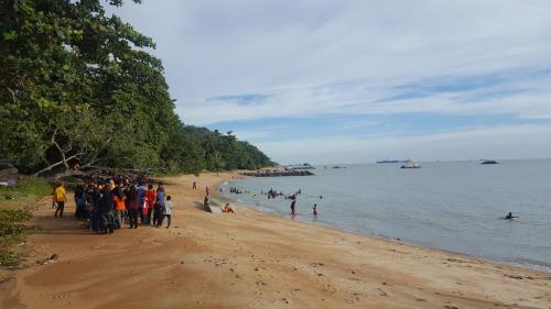 a group of people standing on a beach at Mutiara Chalet in Melaka